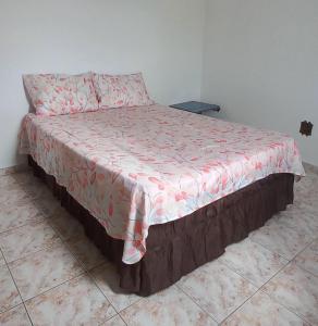 uma cama num quarto com um cobertor vermelho e branco em Casa Temporada em Aparecida com vista para Basílica em Aparecida