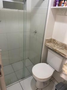a bathroom with a toilet and a glass shower at Aluguel por temporada mobiliado in Natal