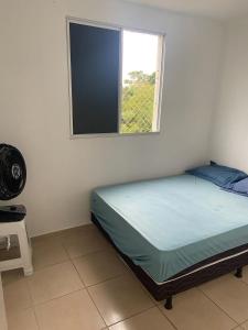 Bett in einem Zimmer mit Fenster in der Unterkunft Aluguel por temporada mobiliado in Natal