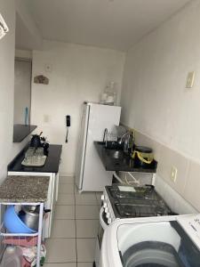 eine kleine Küche mit einem Herd und einem Kühlschrank in der Unterkunft Aluguel por temporada mobiliado in Natal