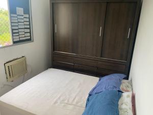 a bed with a wooden headboard in a bedroom at Aluguel por temporada mobiliado in Natal