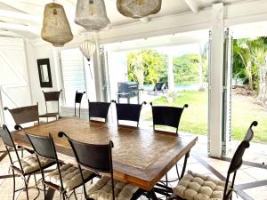 comedor con mesa de madera y sillas en Maison La Samana, en Baie-Mahault