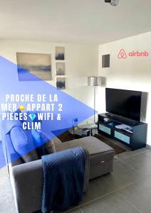 a living room with a couch and a tv at Proche mer Appart 2 pièce Wifi&Clim in Sainte-Maxime