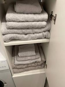 a group of towels are stacked on a shelf at Proche mer Appart 2 pièce Wifi&Clim in Sainte-Maxime