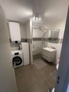 a bathroom with a shower and a washing machine at Proche mer Appart 2 pièce Wifi&Clim in Sainte-Maxime