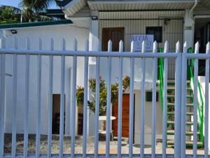 a white picket fence in front of a house at Casa Esmeralda in Lupao