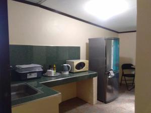 a kitchen with a refrigerator and a microwave at Casa Esmeralda in Lupao