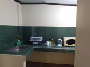 a kitchen counter with a sink and a microwave at Casa Esmeralda in Lupao