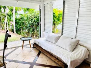 Habitación con cama y mesa en el porche en Maison La Samana, en Baie-Mahault