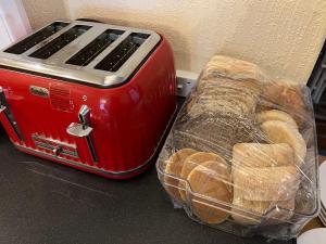 a red toaster sitting next to a basket of bread at The Singlecote Hotel in Lincolnshire