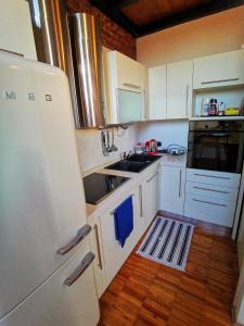 米蘭的住宿－In Da House，厨房配有白色橱柜和白色冰箱。