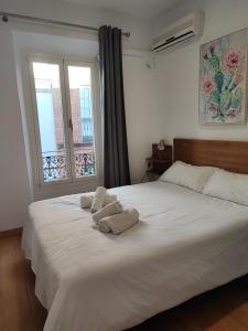 a bedroom with a large white bed with towels on it at Alameda Corner in Seville