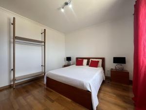 a bedroom with a large bed with red pillows at Villarelva in Ponta Delgada