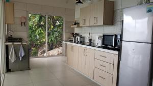 a kitchen with a refrigerator and a microwave at Passage du Soleil in Anse Possession
