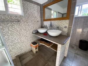 Baño con 2 lavabos y espejo en Passage du Soleil, en Anse Possession