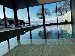 a swimming pool with two chairs in a house at Vakantievilla Eetseveld in Bree