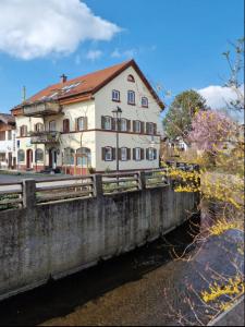 un edificio al lado de un puente sobre un río en Ferienwohnungen Heinrichsberger, en Bad Aibling