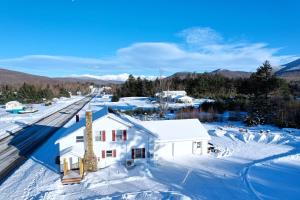 una vista aérea de una casa en la nieve en Renovated farmhouse on snowmobile trail with firepit & mountain views, 10 min from Bretton Woods!, en Twin Mountain