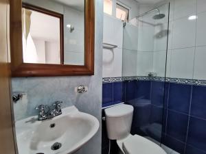 a bathroom with a sink and a toilet and a mirror at aparta-estudio norte de Tunja cristales in Tunja