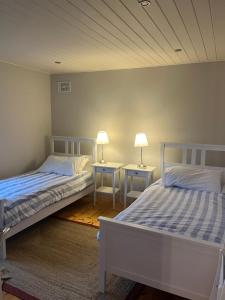 two beds in a room with two lamps on tables at Ballymoney, Wexford - 3 bed beach house with private beach access in Ballymoney Cross Roads