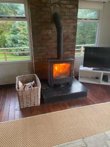 a fireplace in a living room with a brick wall at Ballymoney, Wexford - 3 bed beach house with private beach access in Ballymoney Cross Roads +8 photos