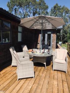 a patio with a table and chairs and an umbrella at Ballymoney, Wexford - 3 bed beach house with private beach access in Ballymoney Cross Roads