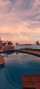 een zwembad met een zonsondergang op de achtergrond bij Espuma de Sal in Mazo