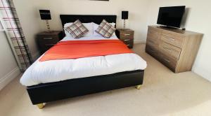 a bedroom with a bed with a television and cabinets at Elegant Double Room with Ensuite in Central Reading in Reading