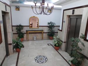 um corredor com vasos de plantas e um espelho em روتانة للشقق المخدومة بالحمرا em Jeddah