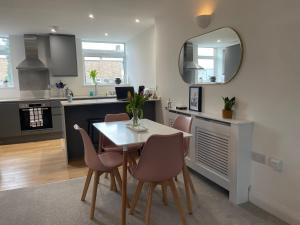 uma cozinha com uma mesa, cadeiras e um espelho em Modern and Comfortable Flat with private parking em Oxford