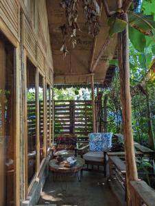 a screened in porch with a couch and a table at Backyard Moshi Eco Bungalows in Moshi
