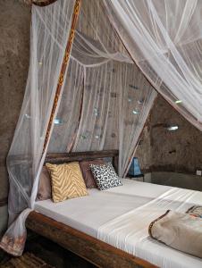 a bed in a room with mosquito netting at Backyard Moshi Eco Bungalows in Moshi
