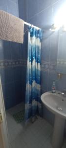 a bathroom with a shower curtain and a sink at Habitación mamá coco in Aguascalientes