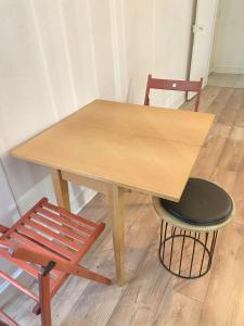 une table en bois avec deux chaises et un tabouret dans l'établissement Super appartement 3T proche Tour Eiffel, à Paris