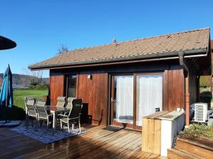 ein Haus mit einer Terrasse mit einem Tisch und Stühlen in der Unterkunft 5 min des pistes de ski Grand studio mezzanine in Viuz-en-Sallaz