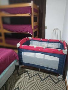ein Koffer auf dem Boden neben zwei Etagenbetten in der Unterkunft Cantinho aconchegante in Campos do Jordão