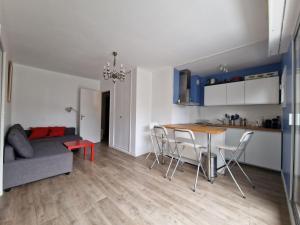 a kitchen and a living room with a table and chairs at Appartement charmant bord de mer in Cabourg +3 photos