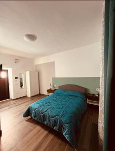 een slaapkamer met een bed met een groen dekbed bij B&B ILSE in Capua