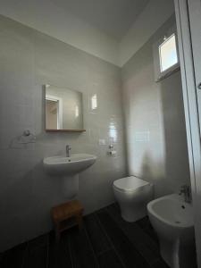 a bathroom with a sink and a toilet and a mirror at B&B ILSE in Capua