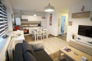 a large living room with a couch and a kitchen at Relaxing Coresi Apartment in Braşov