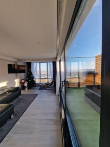 a living room with a christmas tree in the distance at Eco Penthouse&rooftop terrace. in Chişinău