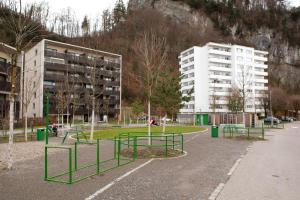 einem Park mit Bäumen und Bänken vor einem Gebäude in der Unterkunft Wohlfühlapartment 24 in Götzis