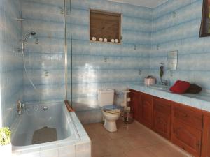 y baño con bañera, aseo y lavamanos. en Chambre avec terrasse vue mer, en Grand-Bourg