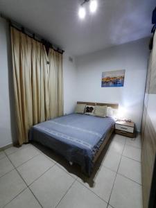 - une chambre avec un lit dans une chambre avec des rideaux dans l'établissement Lovely Home, à Il-Gżira