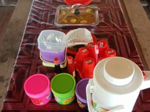 Or Mandira Guest House في Fam: طاولة عليها أطباق وأكواب مختلفة الألوان