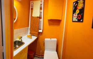 La petite salle de bains est pourvue de toilettes et d'un lavabo. dans l'établissement Spacieux Studio Seventies: voyage dans le temps, à Gannat