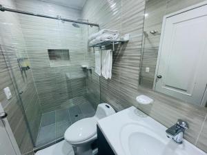 a bathroom with a toilet and a sink and a shower at The Place Hotel Boutique in Cali