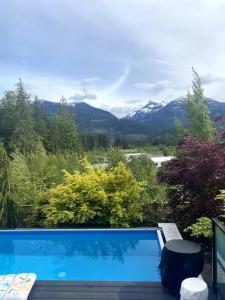 a swimming pool with a view of the mountains at Mountain Serenity Meets Luxury in Squamish