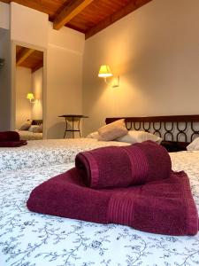 Una toalla morada sobre una cama en Casa Rural Torre del Homenaje, en Belmonte