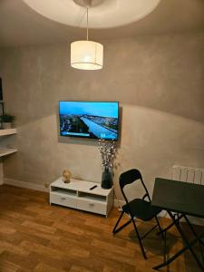 a living room with a tv on a wall at studio centre-ville agréable in Vendôme